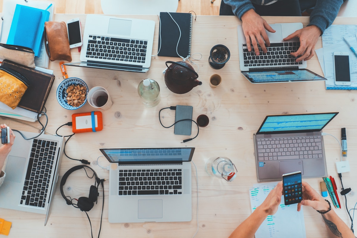 A technology team working together around laptops in a bright office.